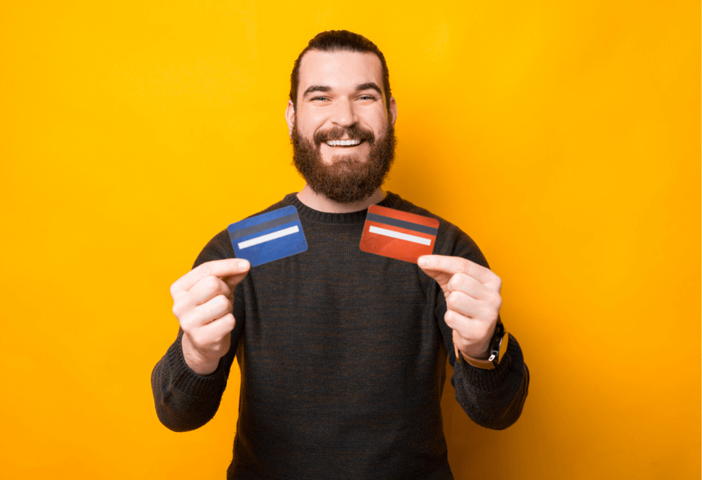 Man smiling with two credit cards