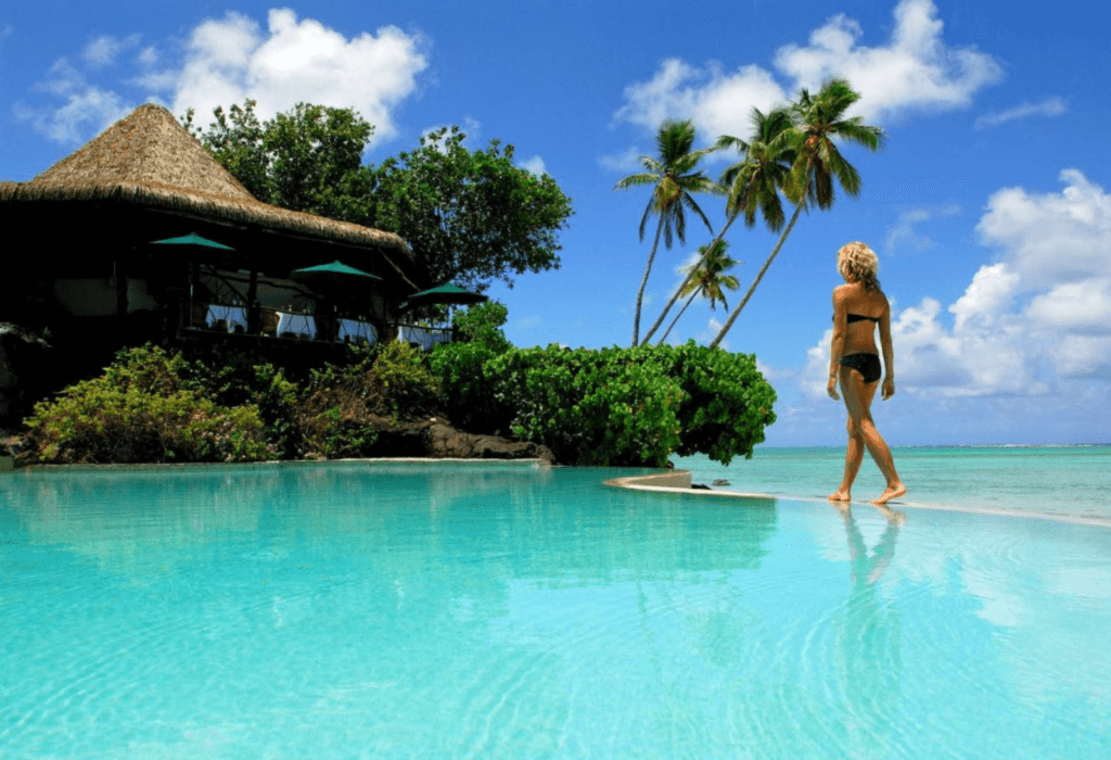 A woman walks by the pool at Pacific resort Aitutaki