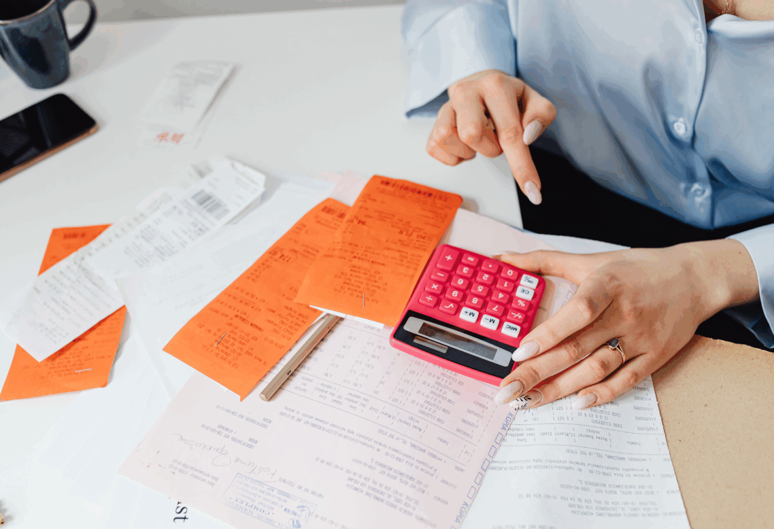 Someone using a calculator to input budget into a spreadsheet