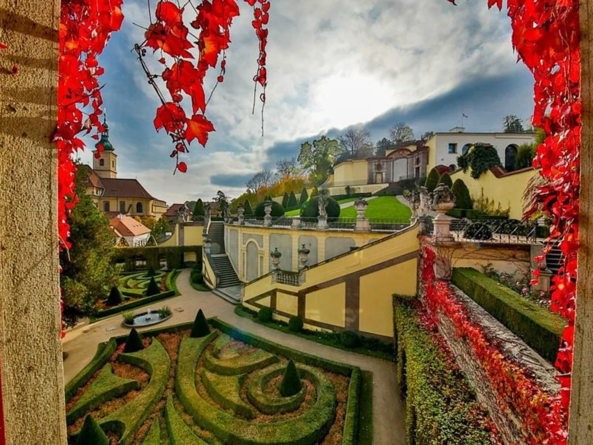 Aria Hotel Prague ith greenery and red flowers shown outside a hotel window